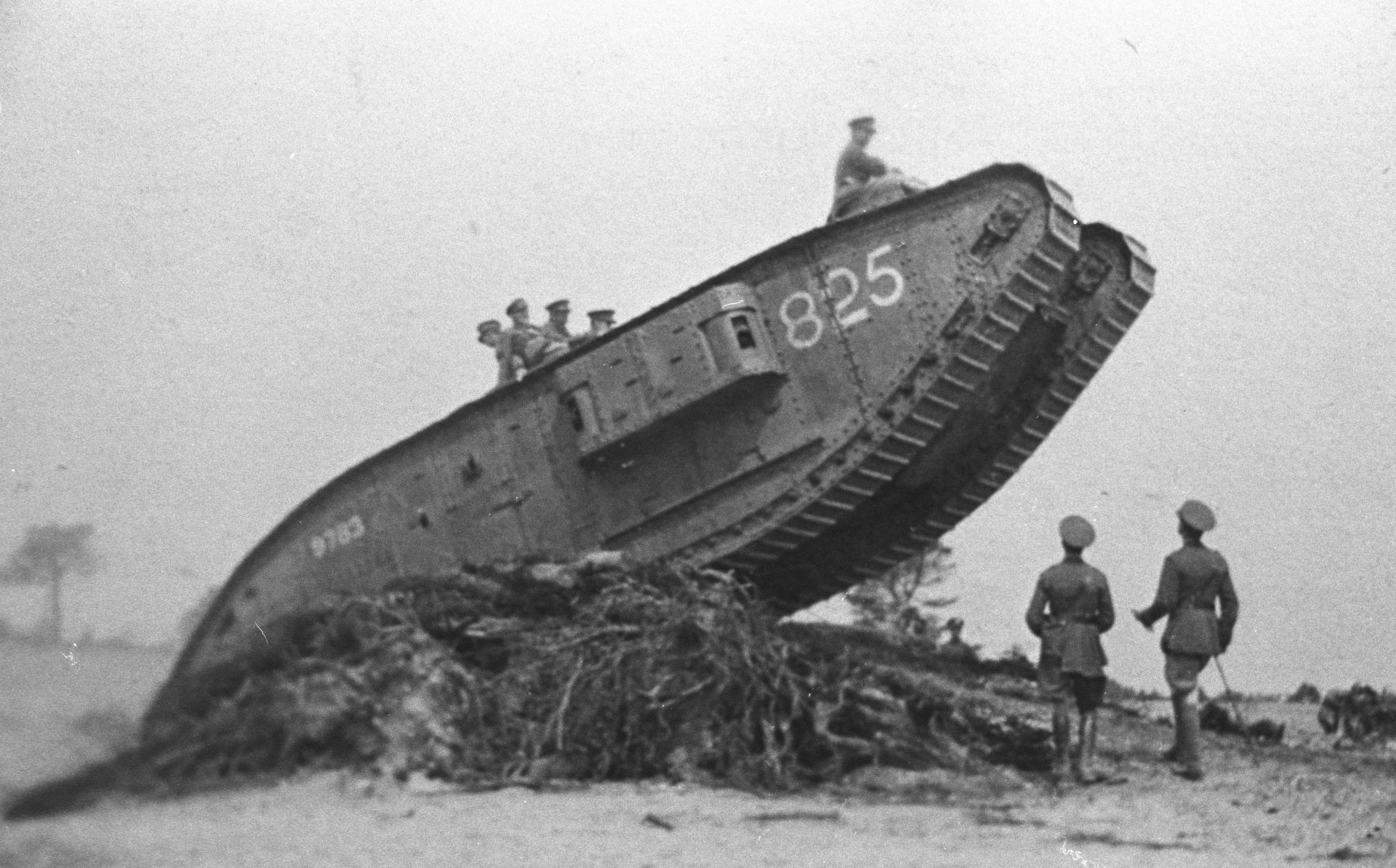 P_Mark-V-star-female___1556-A5 Black and white photograph of Mark V* on a rise with the front in the air. There are 5 men on the tank and two on the ground. The tank has 825 written at the front and 9783 written at the back.