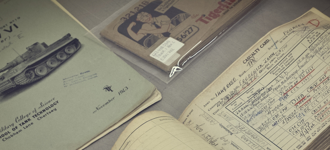 Archive & Library resources A close up image of several items in the Museum archive. The top left shows an old book about the Tiger 1 Tank from The School of Tank Technology, November 1943. To the top of the image an original Tigerfibel in a protective bag., The bottom of the image shows a casualty card from WW2.