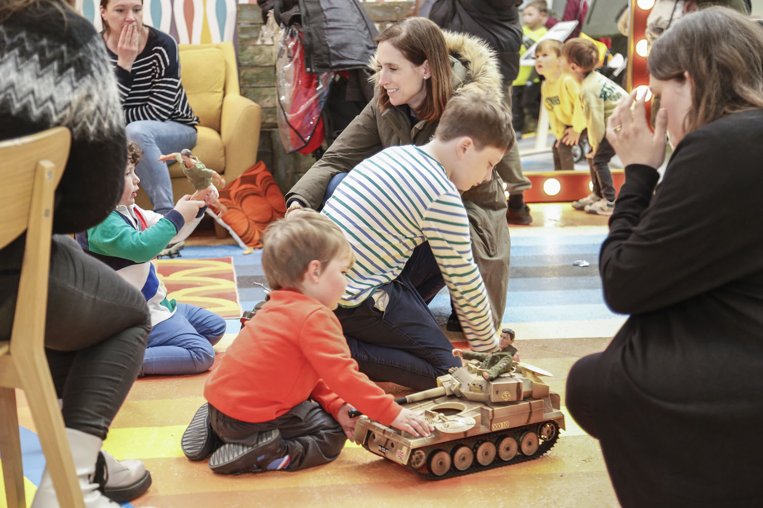 A colour image of children playing with a toy tank.
