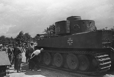First captured tiger A black and white image of one of the first captured Tigers. Men are inspecting the tank and stood around the front.