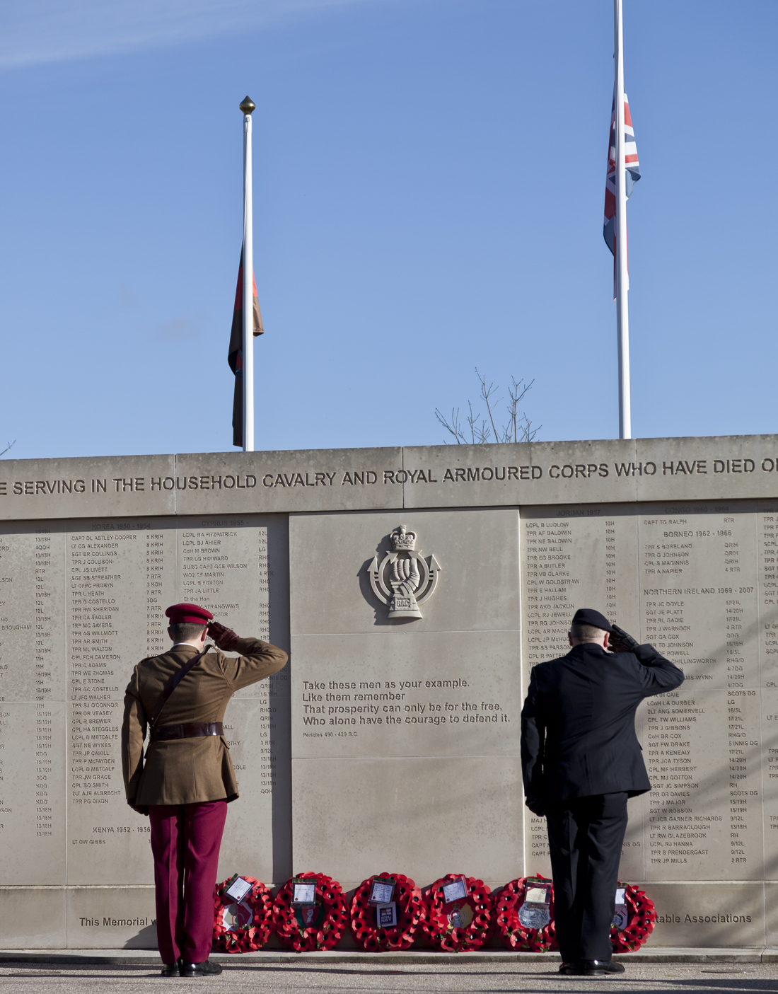 Remembrance Day at The Tank Museum Sunday 11th November 2012. Two men salute a memorial wall