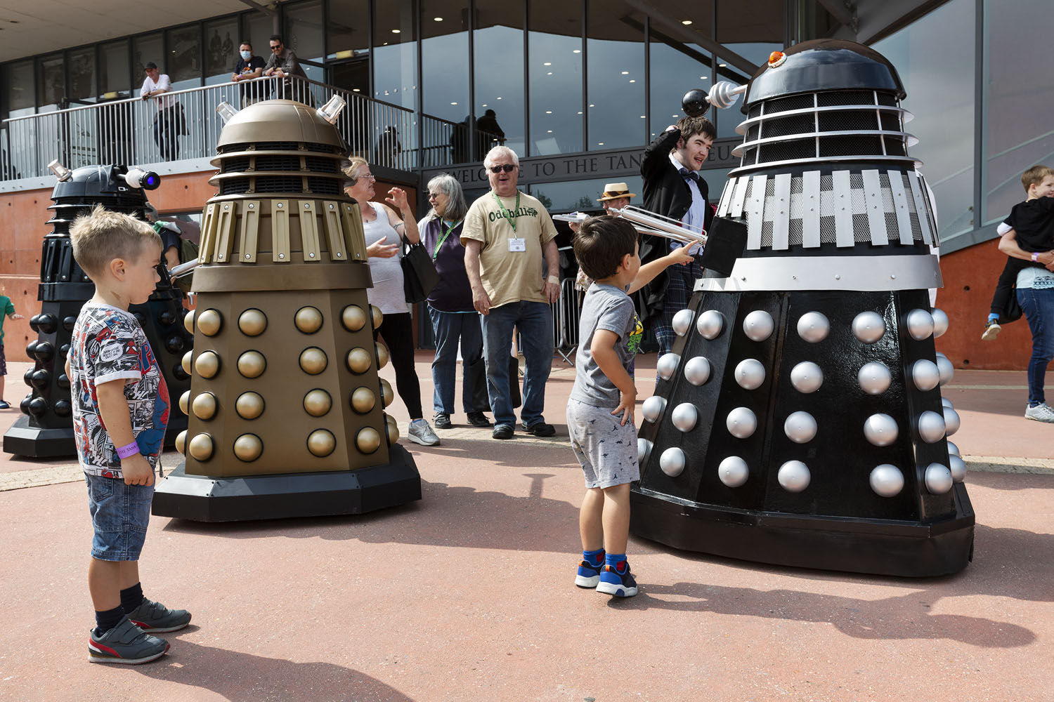 2021_Model_Show041 The colour image is showing two Daleks outside The Tank Museum with two children looking at them whilst others are stood behind