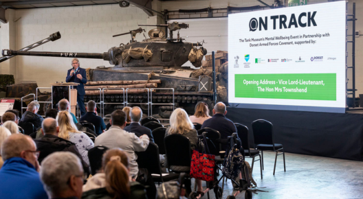 On Track feature On Track event, visitors sat on chairs in front of a screen and fury tank.