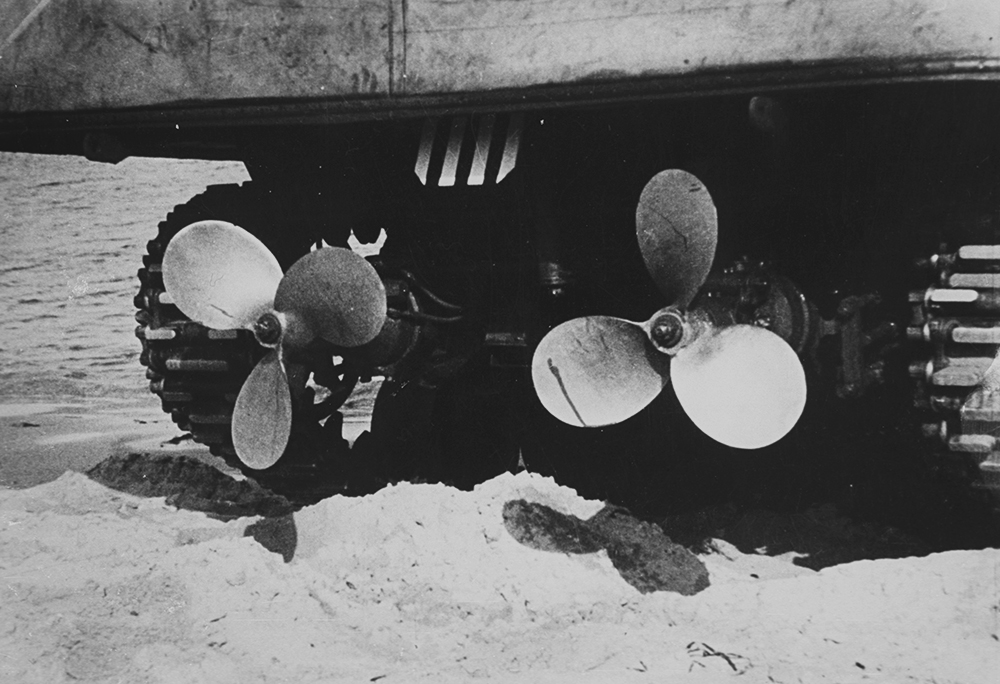 The propellers of a Duplex-Drive Sherman A black and white photograph of two propellers behind a tank on a beach