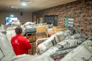 _DSC0560 Person in red top surrounded by piles of parcels.