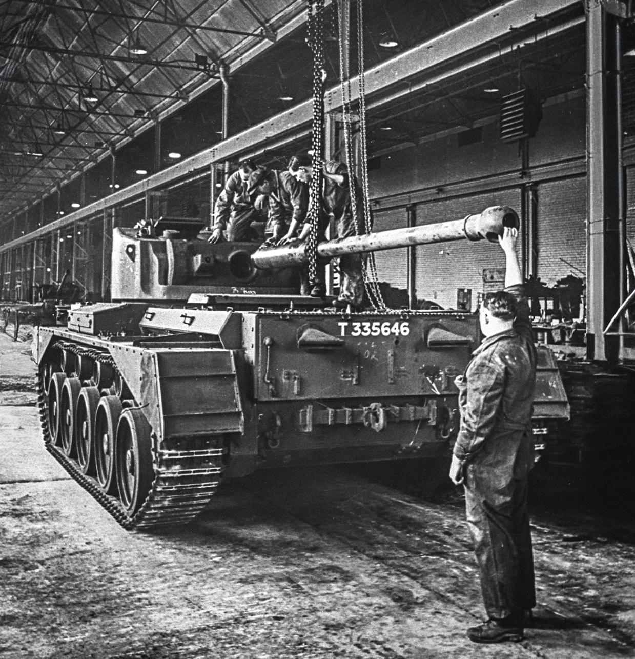 Comet Gun Article Picture 2 Black and white image of a Comet tank on the factory production line - in the final stages of having its gun barrel being lifted into place.
