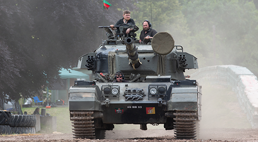 Centurion 13 Photograph of a green tank on a dusty arena, with two men in black overalls in the turret