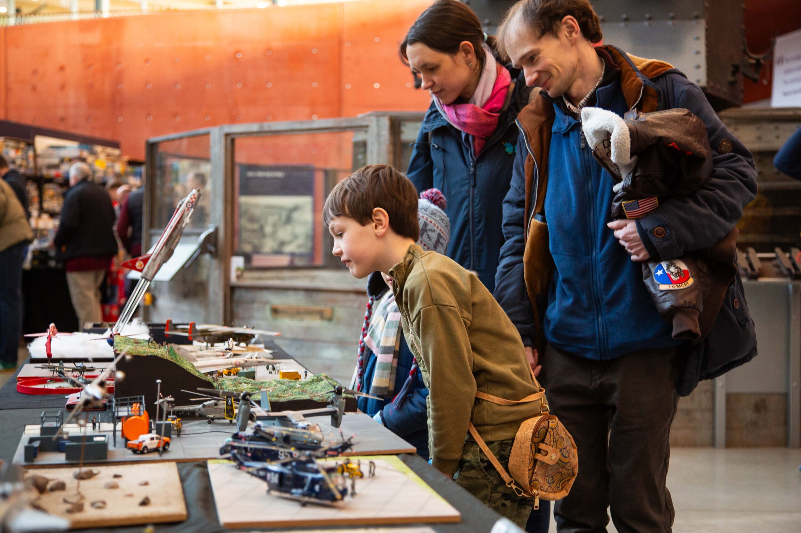 South West Model Show February Family looking at scale models laid out on a table.