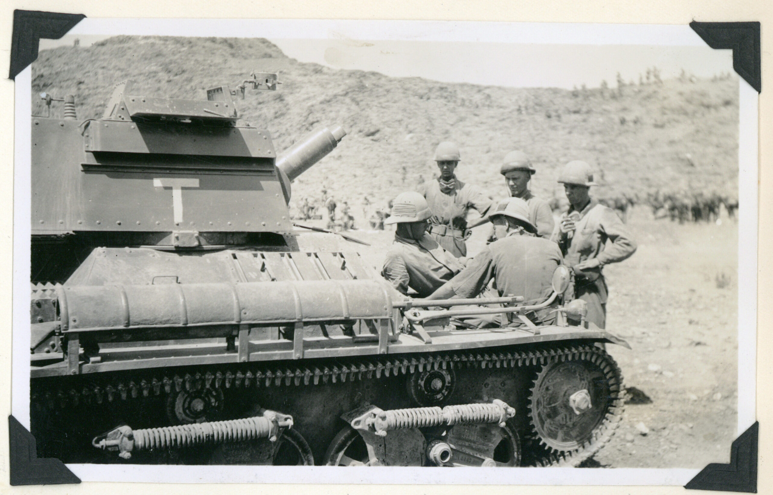 Waiting to go into Action 1935 - Reflections from the past article Black and white photograph taken in August or September 1935 showing 5 tank crewmen in uniform, relaxing in front of their tank.
